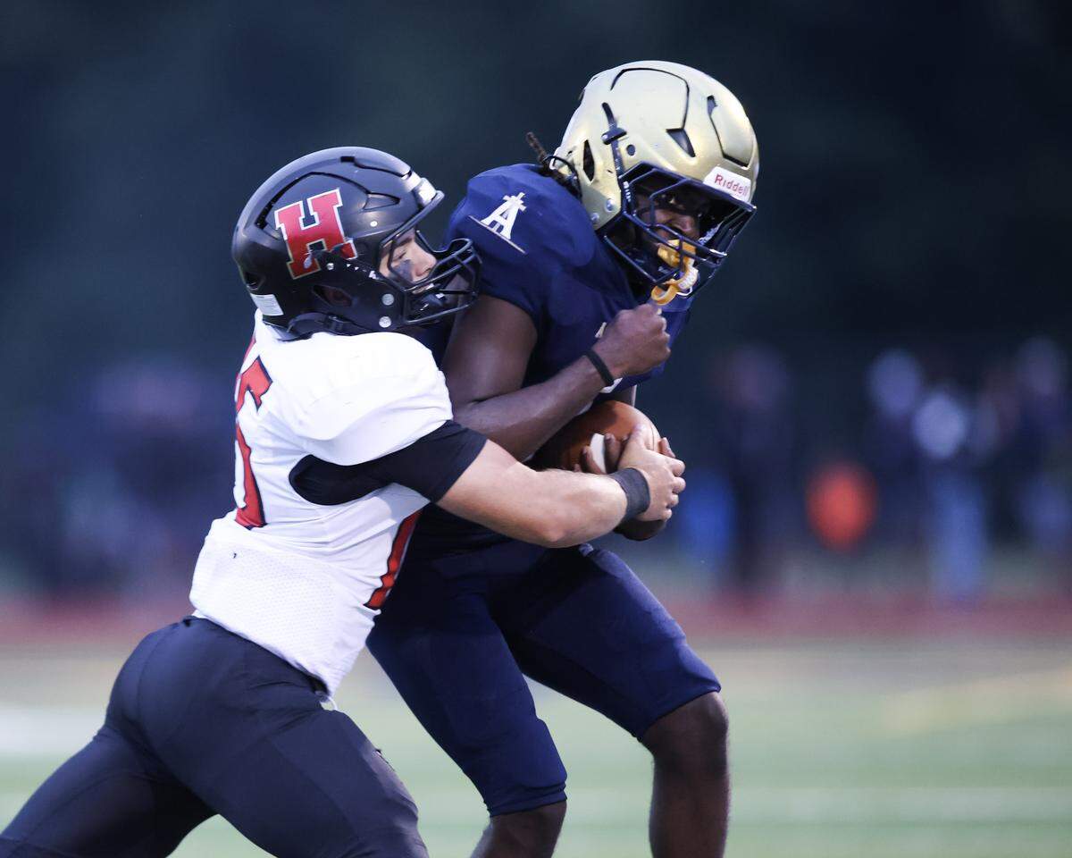 Highland's Chase Wilson wraps up Althoff’s Jayden Ellington during Friday night’s non conference game in Belleville.