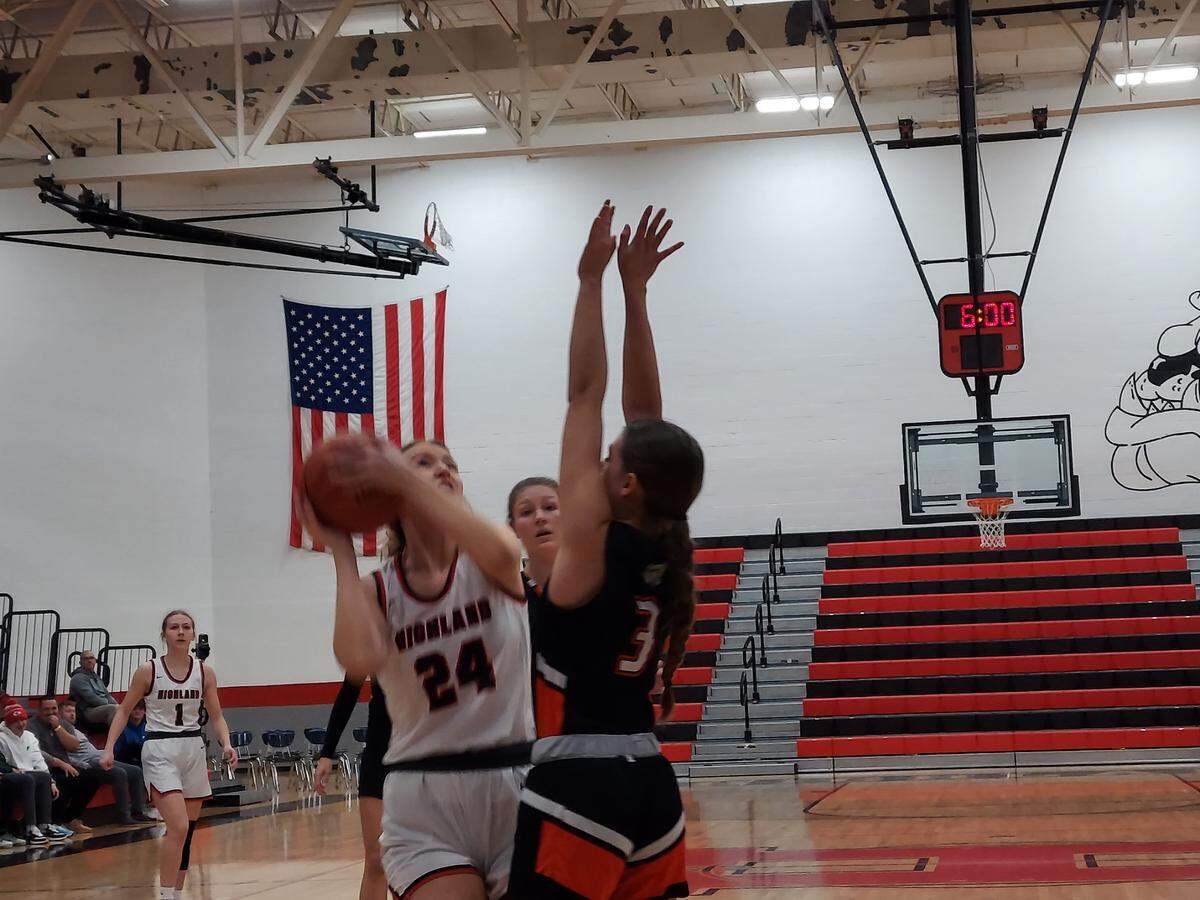 Highland junior post Larissa Taylor goes up for a shot over Waterloo’s Kristin Smith during during the first game of the 31st annual Highland Optimist Scott Credit Union Shootout on Saturday, Jan. 7. Highland ultimately prevailed 54-52.