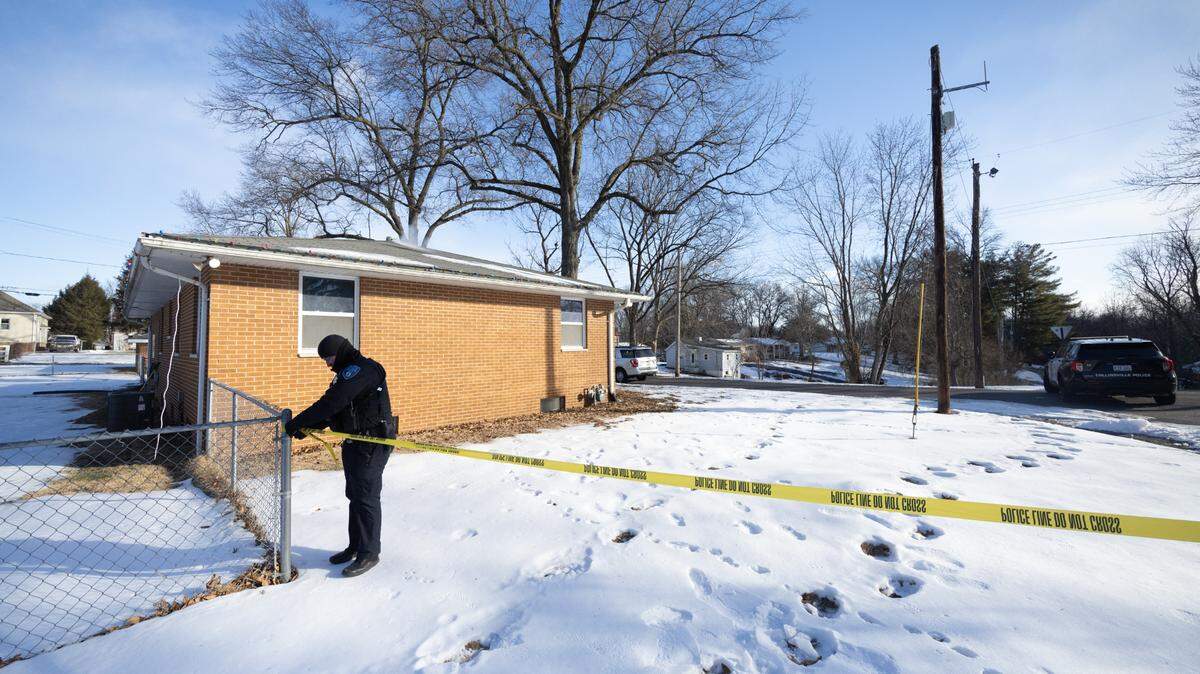 A police officer secures yellow tape around a home on Olive Street in Collinsville, where a fatal shooting occurred early Tuesday morning.