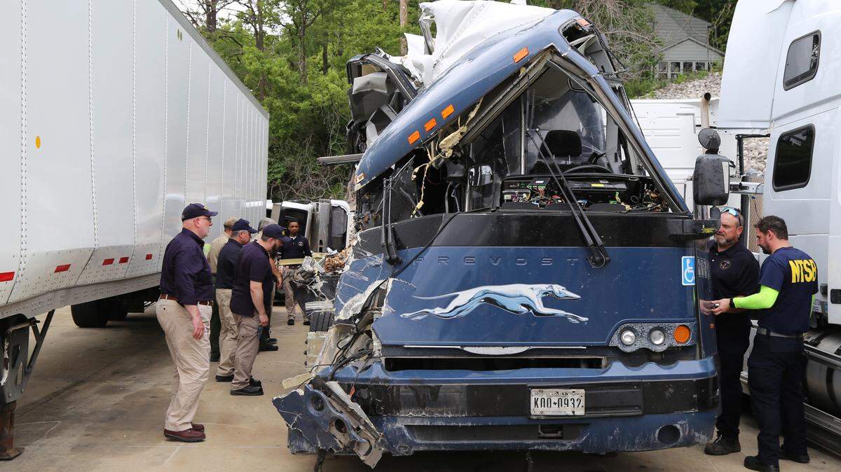 In this July 13, 2023 photo, a National Transportation Safety Board team examines the Greyhound motorcoach involved in a crash that occurred a day earlier on I-70 near Highland, Illinois.