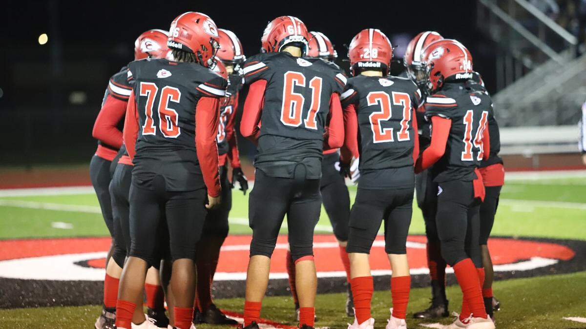 Members of the Warriors varsity football team huddle on the field at Friday night’s homecoming game, as shown in this photo posted on Granite City High School’s Facebook page. A man in the crowd was later charged with possessing a handgun.