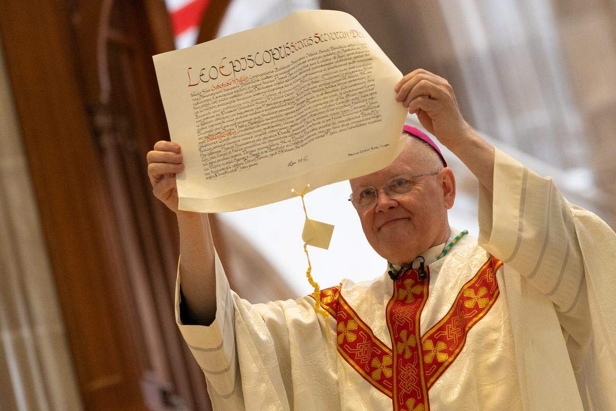 The Rev. Godfrey Mullen holds up a papal bull during his installation as bishop of Belleville at the Cathedral of St. Peter on Friday. That’s the official document of his appointment by Pope Leo.