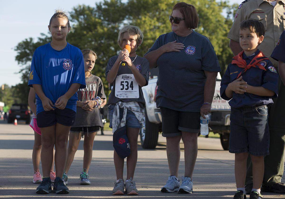 Chloe Smith sings the national anthem at the start of an annual 5K run that honors her father, Senior Airman Bradley R. Smith, who was killed in Afghanistan.