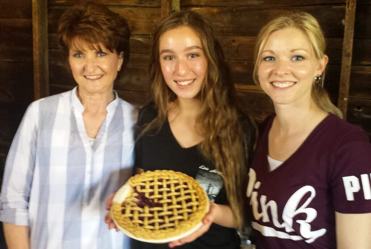 Grace Thompson, 13, center, holds her Ozark Mountain Berry Lattice Pie, which took first place in the Traditional Fruit category at the first Fezziwig's Pie Baking Competition. Her mother, Amanda Thompson, right, won in the Baker's Choice category with her Lavender Lemon Pie. At left is Sheila Clement, Amanda's mother. This year's contest will take place June 23.