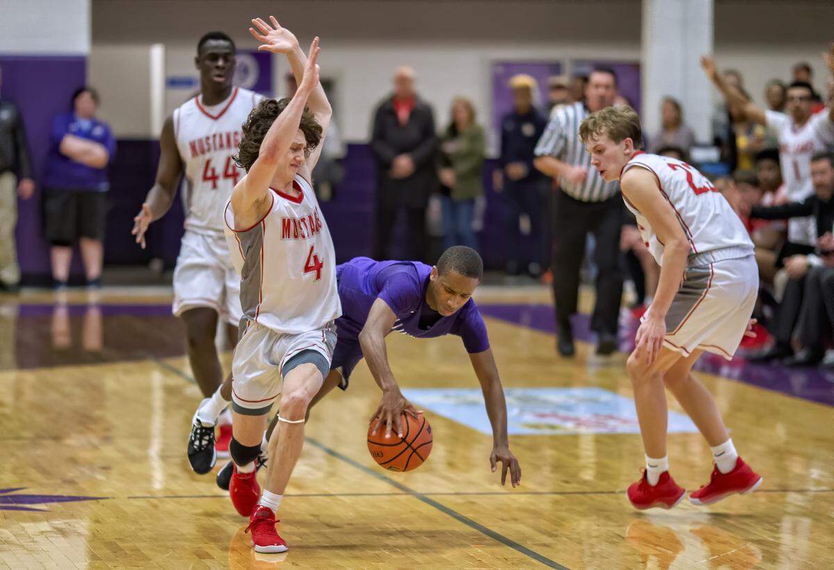 Collinsville’s Cawhan Smith dives for the ball against Mundelein’s Conor Enright during the championship game of the Collinsville Prairie Farms Holiday Classic Tournament in 2019. In this week’s BND sports poll, readers chose this yearly hoops extravaganza as their favorite holiday tournament.