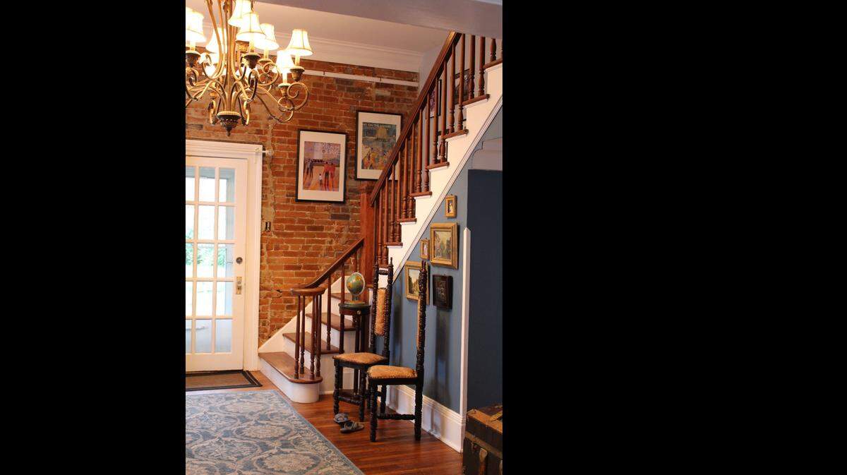 The side entry in the McCullough family’s 1874 brick home on Abend Street in Old Belleville Historic District has a high ceiling, exposed brick wall and stairs to the second floor.