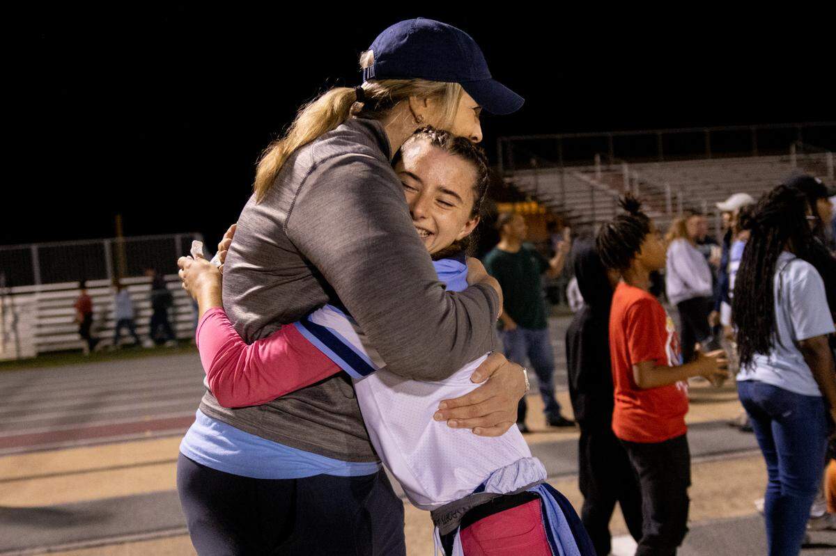 Belleville East assistant coach Amanda Kemezys gives a hug to Ary Kohler (2) after scoring the game-winning touchdown against Belleville West on Wednesday in Belleville.