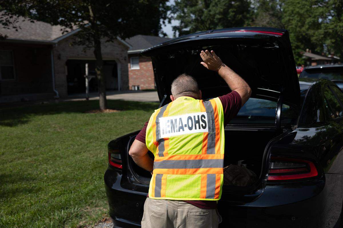 A damage assessment team member retrieves something from his car in front of a Belleville house on July 30, 2024 to discuss effects of July flooding that swept through the region after heavy rain. St. Clair County issued a disaster proclamation and hopes to qualify for state and federal aid for disaster victims..