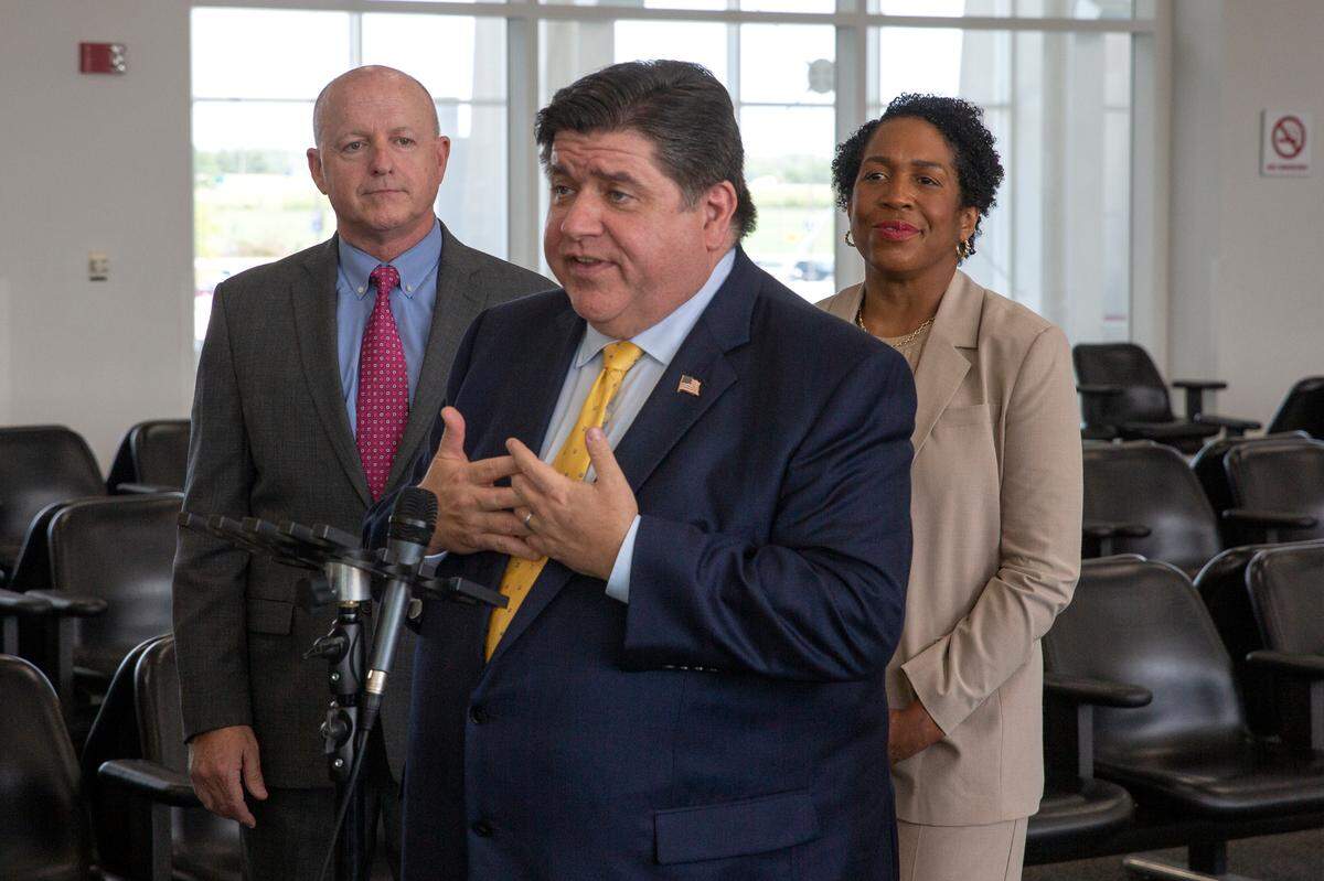 Illinois Gov. J.B. Pritzker answers questions from the press about the MidAmerica St. Louis Airport expansion on Tuesday, June 13, 2023 at MidAmerica St. Louis Airport. Behind him stand MidAmerica St. Louis Airport Director Bryan Johnson, left, and Illinois Lt. Gov. Juliana Stratton.