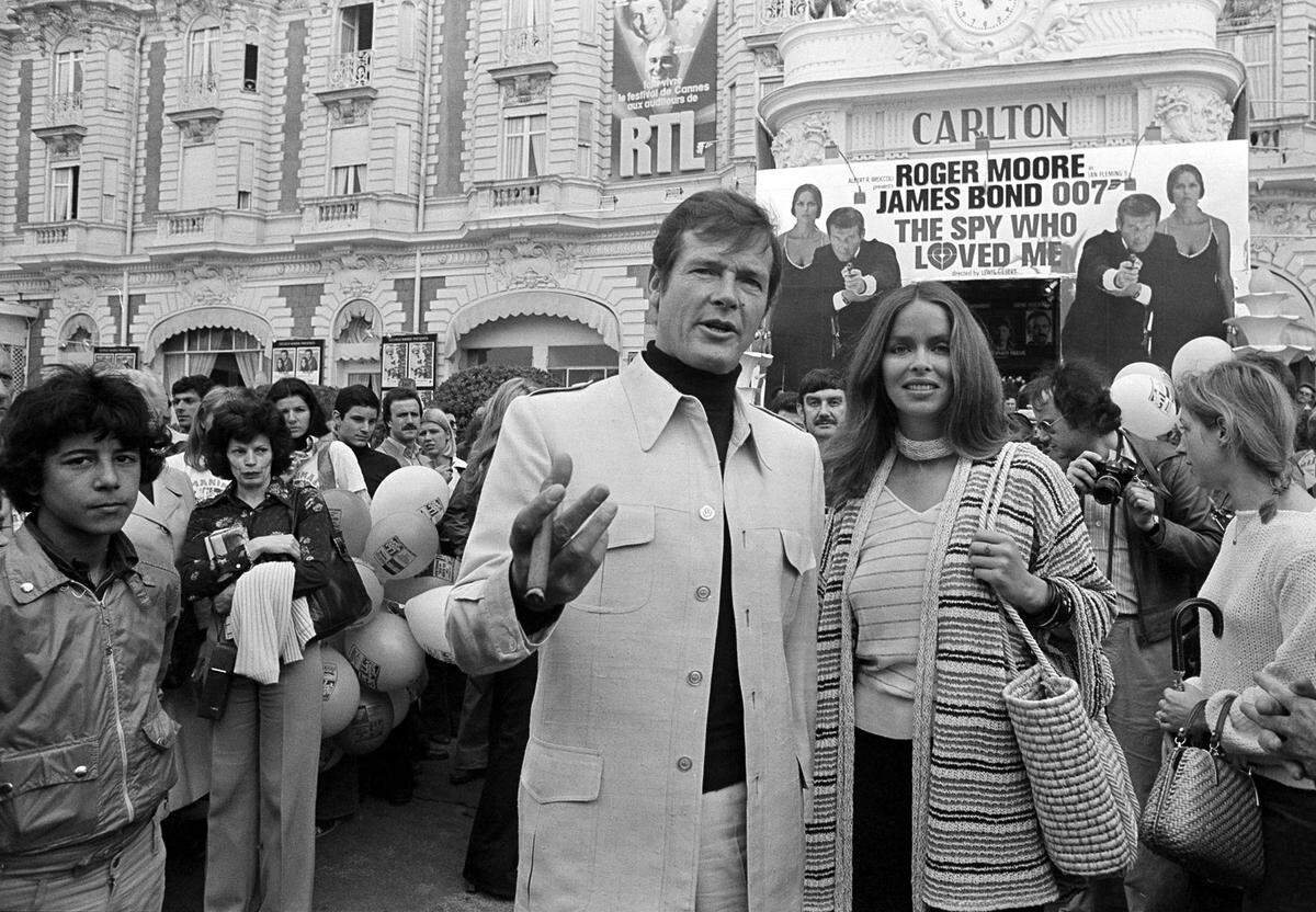 In this May 20, 1977 file photo, actor Roger Moore, alias British secret agent James Bond, is accompanied by co-star Barbara Bach as they arrive for the screening of their latest 007 feature, “The Spy Who Loved Me,” during the Cannes Film Festival at the French Riviera. Moore, played Bond in seven films, more than any other actor.  Roger Moore’s family said Tuesday May 23, 2017 that the former James Bond star has died after a short battle with cancer.