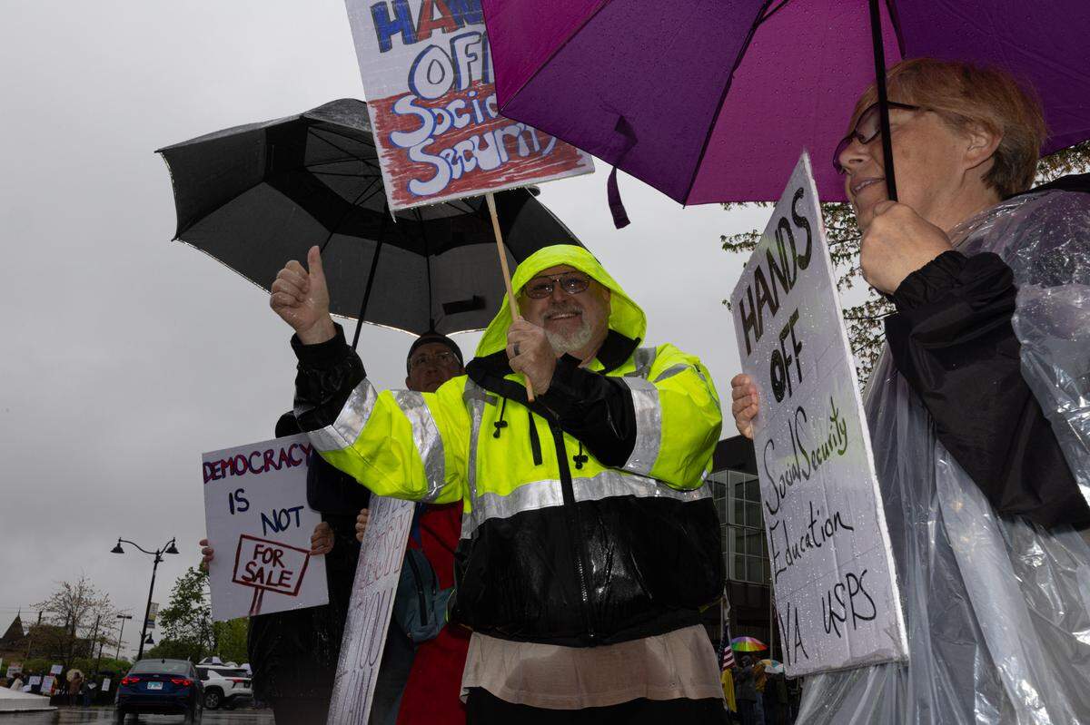 Tom Nilges of Waterloo holds a sign against Social Security cuts along with his wife Sue during a protest at the Belleville Public Square. “If Trump don’t shut down for the rain, than neither will we,” Tom Nilges said.