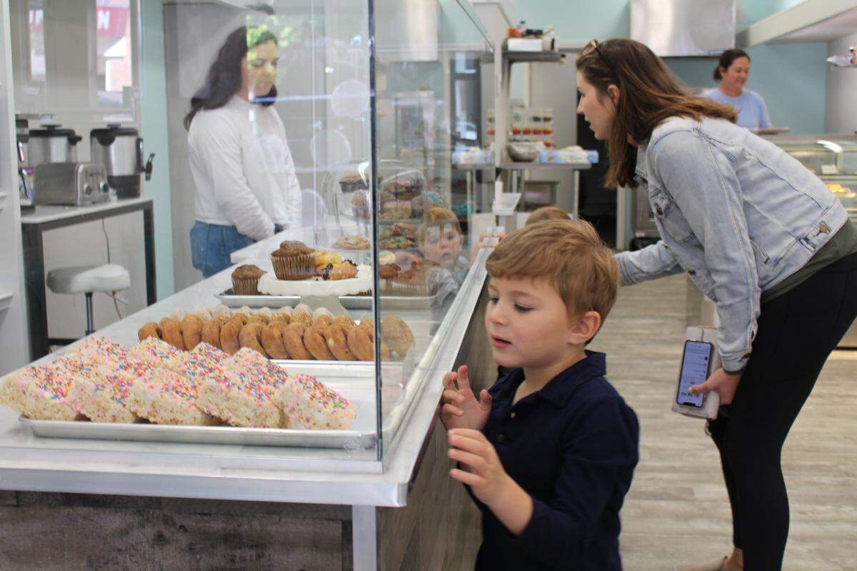 Connor Boyer, 4, sets his sights on a giant Rice Krispies treat while his mother, Alyssa, shops with son Owen, 2 (reflected in glass), at Sugar Fix Bakery in Belleville. Taylor Waterkotte waits to take their order.
