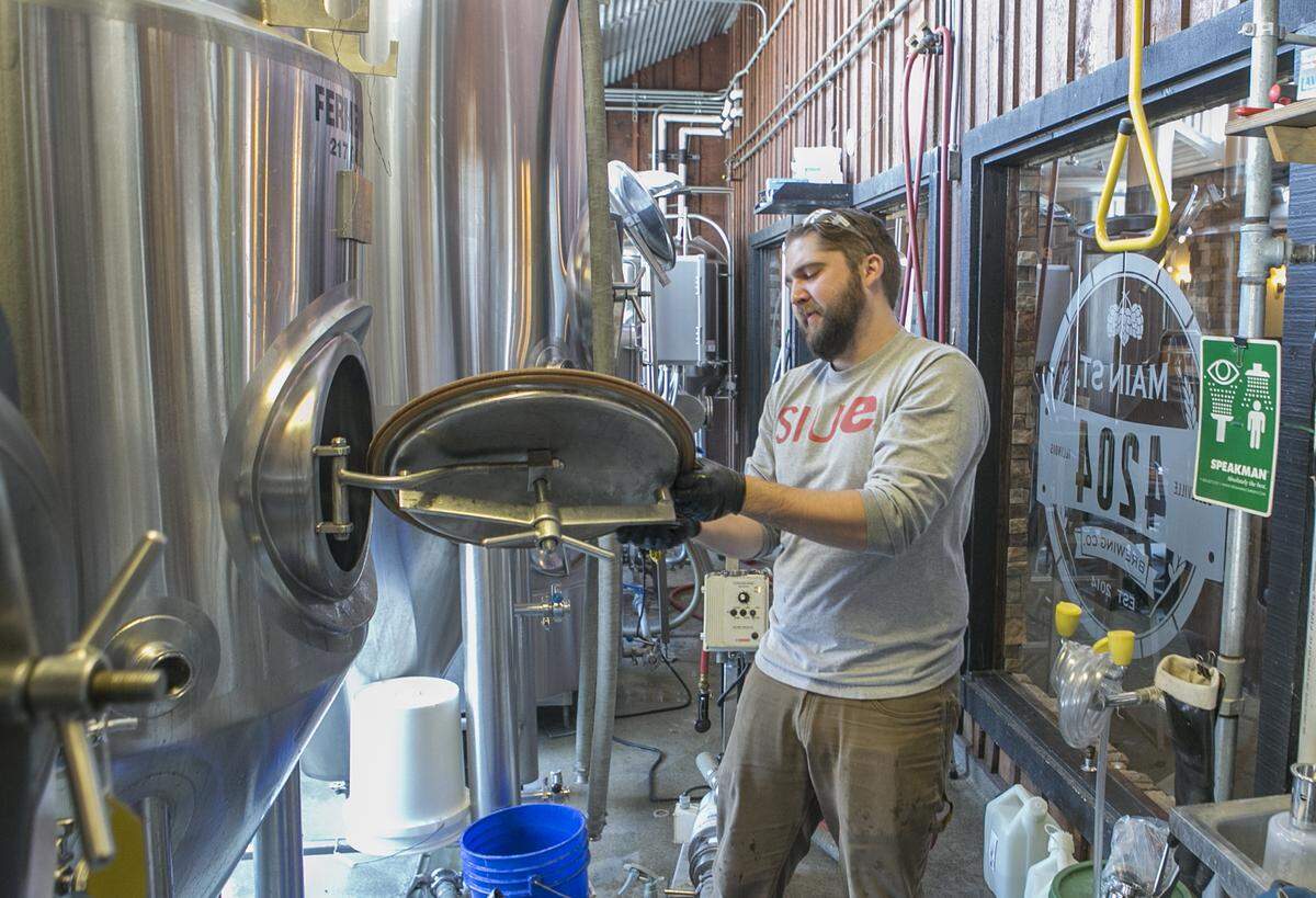 Brewer Cory Sanftleben cleans and prepares the brewery equipment inside 4204 Main Street Brewing Co.’s restaurant. Sanftleben will begin brewing small batch items exclusive to the restaurant and helping lead brew classes. The restaurant’s brewery has been idle for over a year.