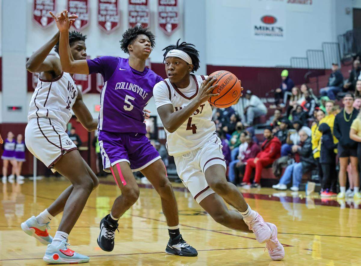 Belleville West’s Brandon Scott drives to the basket against Collinsville’s Jamorie Wysinger during Friday night’s Southwestern Conference game. The Kahoks ultimately posted a 71-60 victory.