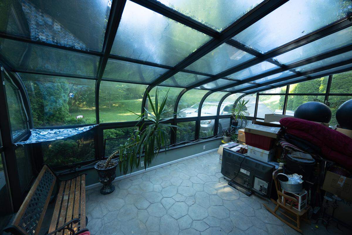 At the front of the home, a glass room provides an all-season refuge.