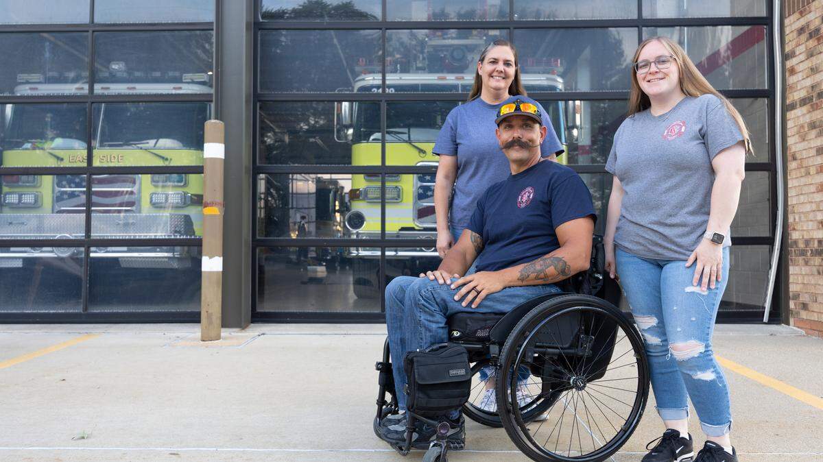 (Left to right) Patty, Brad and Zooey Blanchard pose outside of East Side Fire District firehouse in Belleville. Brad Blanchard used to work out of the firehouse before he was paralyzed in a motorcycle accident in 2021, and still performs ocassional duties for the fire station.