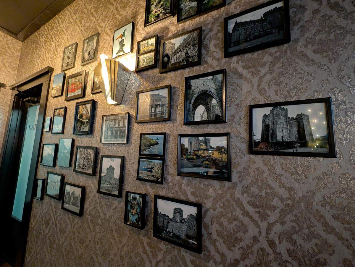 A display of Irish architecture and other photos adorns the back wall at The Harp Pub in Belleville.