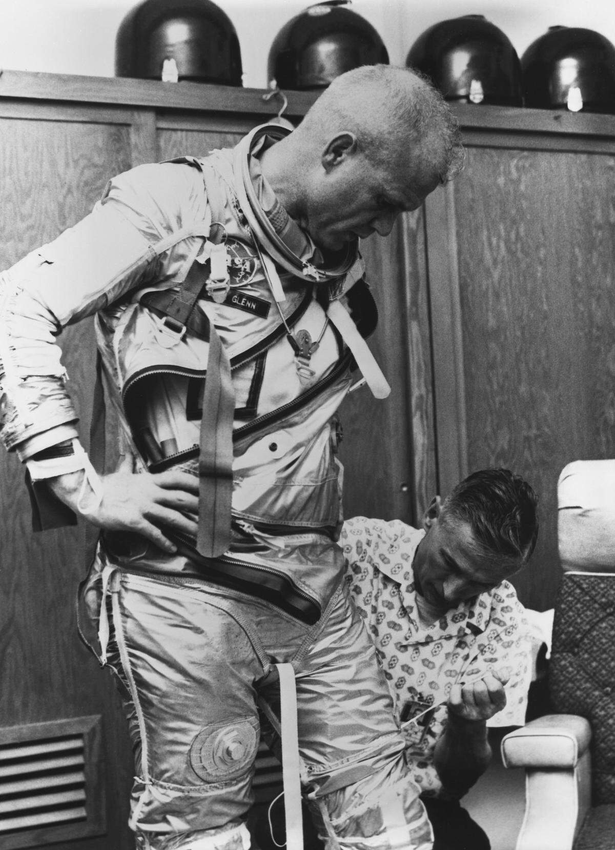 Joe Schmitt assists astronaut John Glenn as he prepares for a practice mission in 1962.
