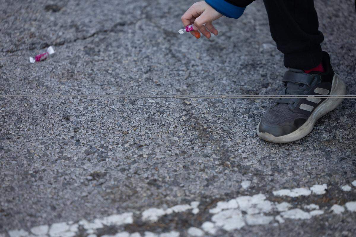 Every float throws candy during the Santa parade, with soft candy being in the majority. Here, a child stepped from the barricade to take the last remnants of the parade.