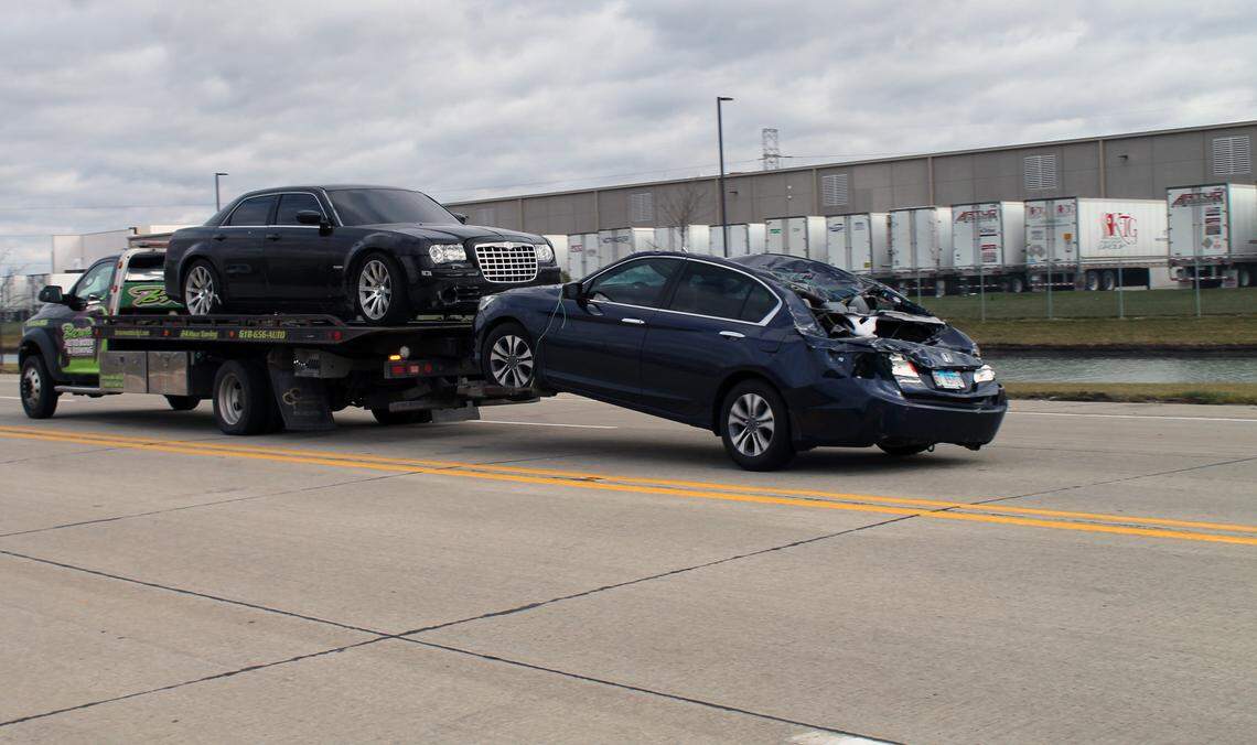 A tow truck removes a damaged car from the Amazon warehouse parking lot Dec. 11, 2021, in Edwardsville after a “significant weather event” damaged the building Dec. 10, 2021.