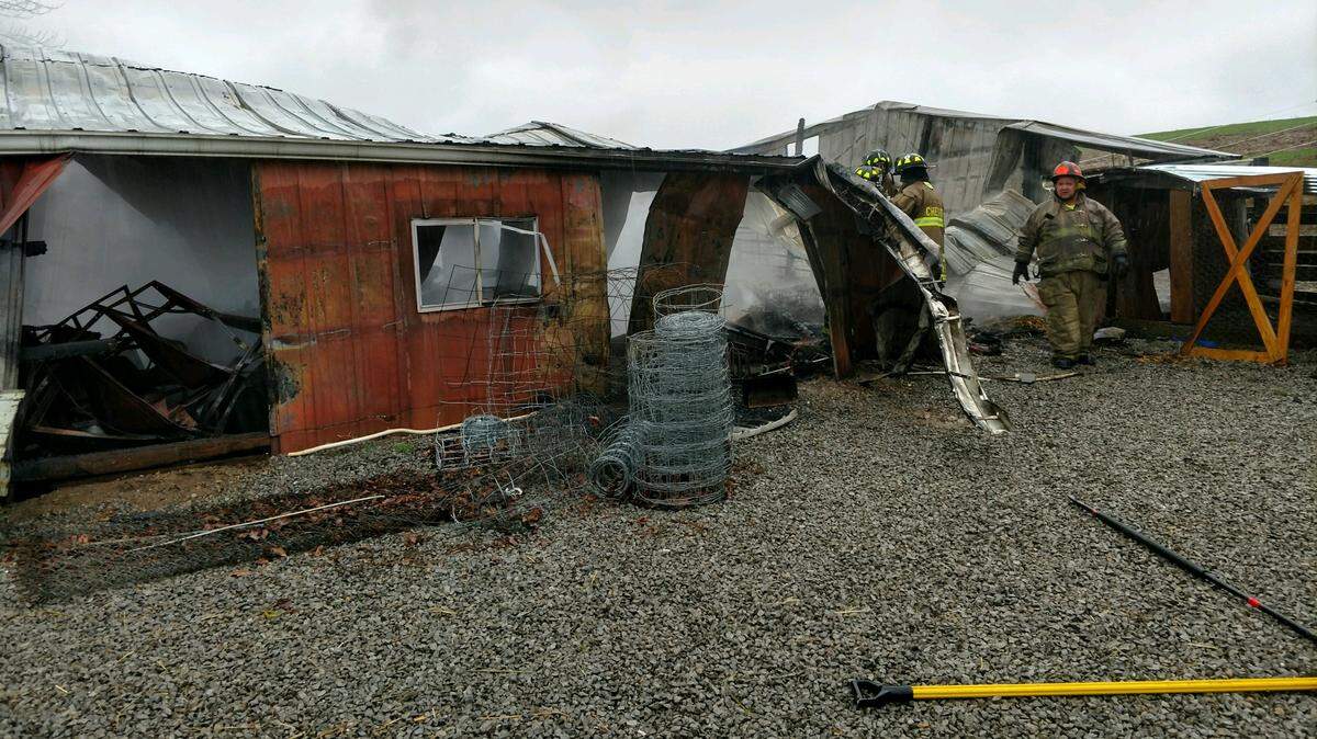 Crews work at a barn that caught fire Thursday morning at 10934 Mount Summit Road. Fire Chief Marty Bert said approximately 20 goats died in the fire, which may have been caused by faulty wiring.