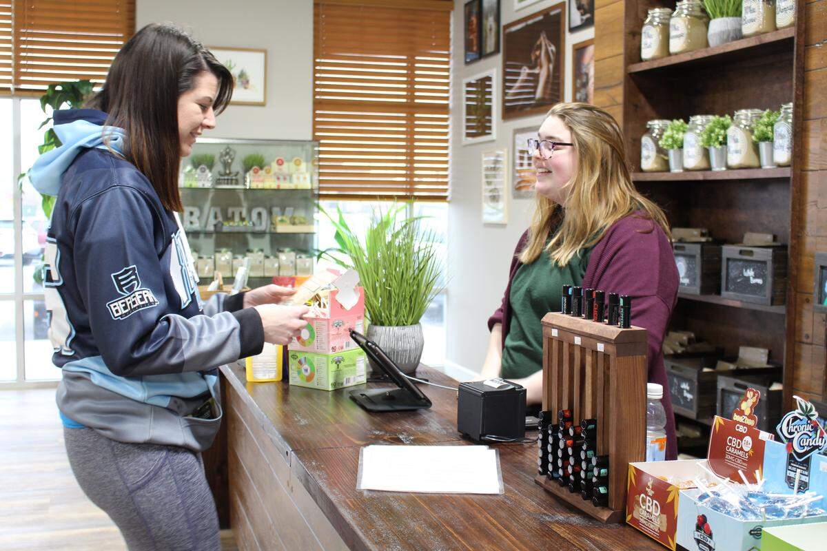 Jocolyn Accola buys kratom powder from clerk Anna Scott at the CBD Kratom store in Belleville. Accola, a former Marine, uses it to alleviate shoulder and hip pain.