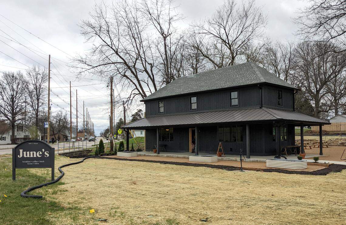 The exterior of June’s Breakfast + Patio with raised garden areas and original water pump
