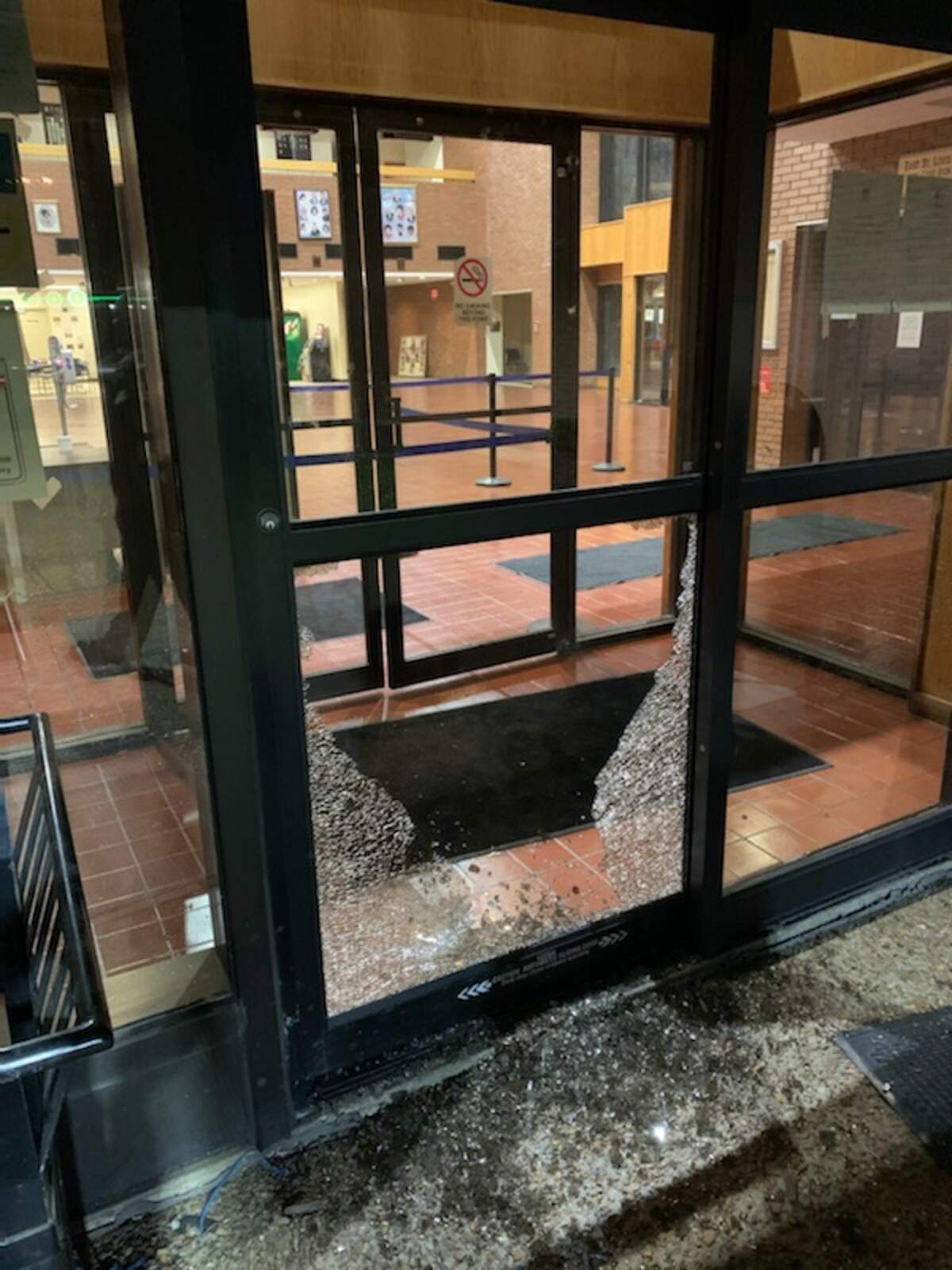 Glass litters the entry way to East St. Louis City Hall Sunday night. The window was struck by a gunfire from a gas station on the opposite side of the City Hall parking lot.