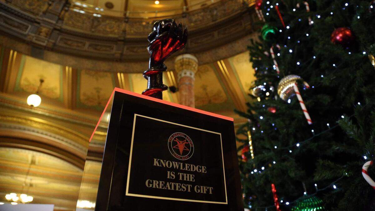 The Satanic Temple-Chicago put a sculpture of the forbidden fruit in the Illinois Capitol next to a Nativity scene and Menorah for the holidays. Lux Armiger, group chairperson, says it’s about religious freedom.
