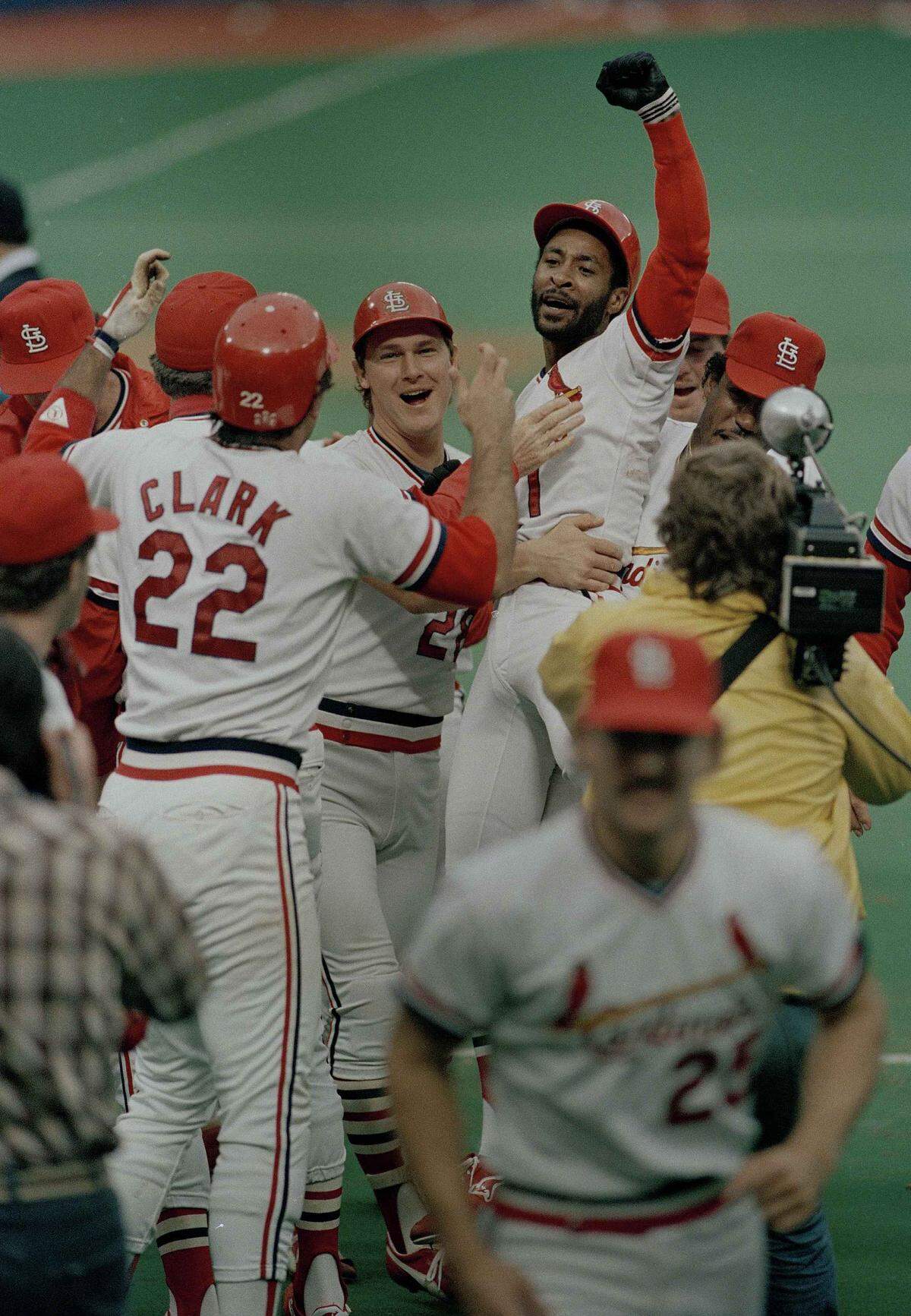 Ozzie Smith reacts to the crowd and his teammates after hitting the game-winning home run in the ninth inning to defeat the Los Angeles Dodgers 3-2, in St. Louis, Mo., Oct. 14, 1985. Smith’s teammate Tommy Herr pats his chest. The Cardinals went up one game on the Dodgers to take a three game to two advantage in the National League playoffs. (AP Photo/Doug Pizac)