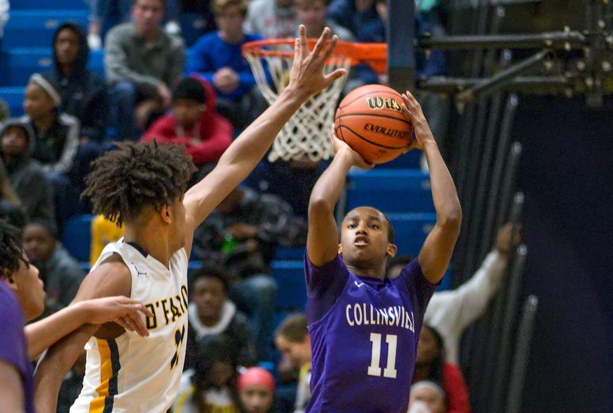 Collinsville Cawhan Smith shoots over O’Fallon Shaun Riley II during Friday’s s conference game at O’Fallon High School.