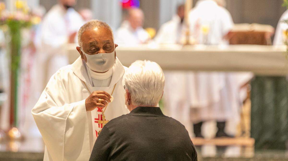 Archbishop of Washington Wilton D. Gregory, former bishop of the Catholic Diocese of Belleville, gives communion during a Mass of ordination and installation for new Bishop Michael G. McGovern on July 22 at the Cathedral of St. Peter in Belleville.