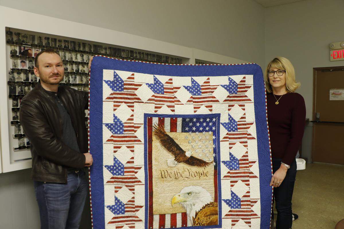 Highland veteran Logan Wolf, left, and his mother Angela Kim hold the Quilt of Valor he was honored with for his service in Afghanistan.