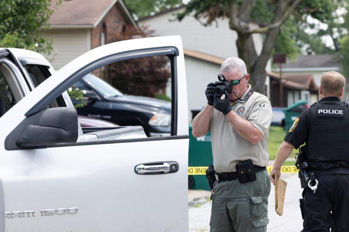 An officer investigates a crime scene on Maple Tree Lane in Cahokia Heights, Ill. on July 10, 2024.