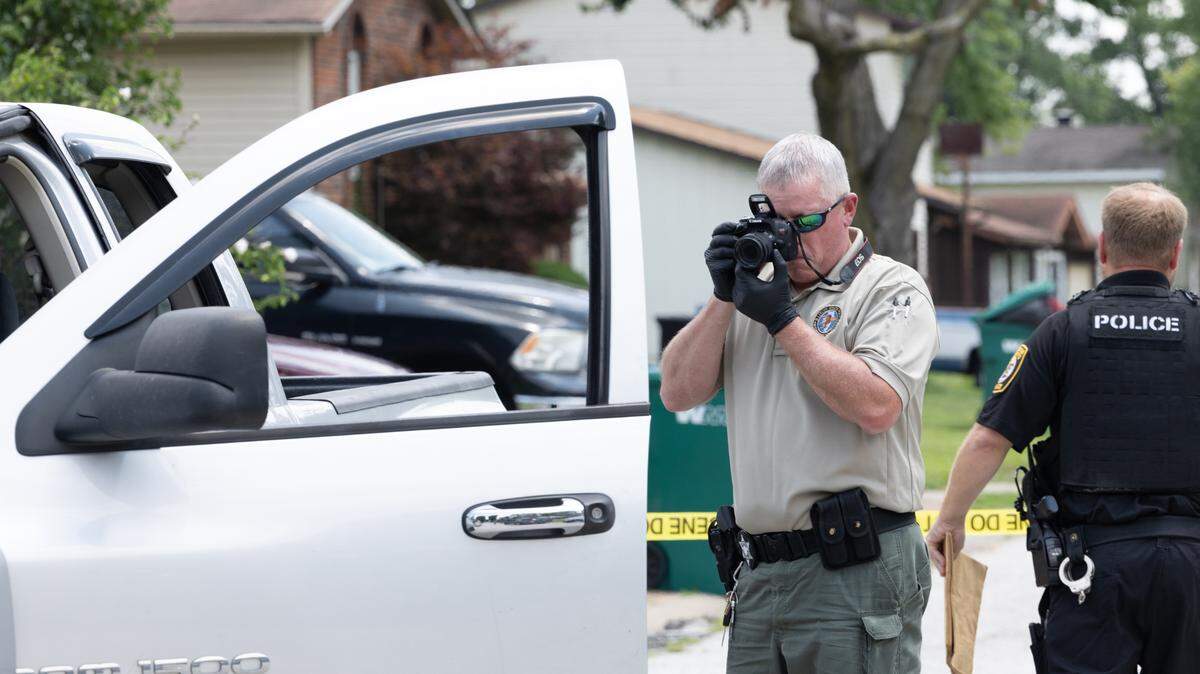 An officer investigates a crime scene on Maple Tree Lane in Cahokia Heights, Ill. on July 10, 2024.