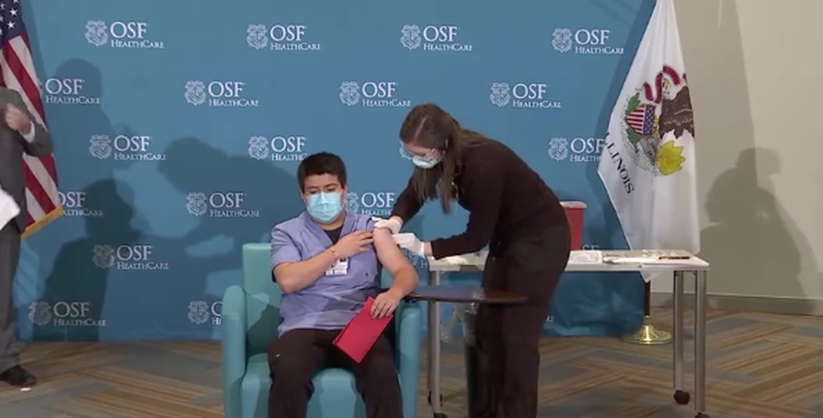 Juan Fernandez, a 22-year-old transporter for Saint Francis Medical Center, is vaccinated Friday morning in Peoria.
