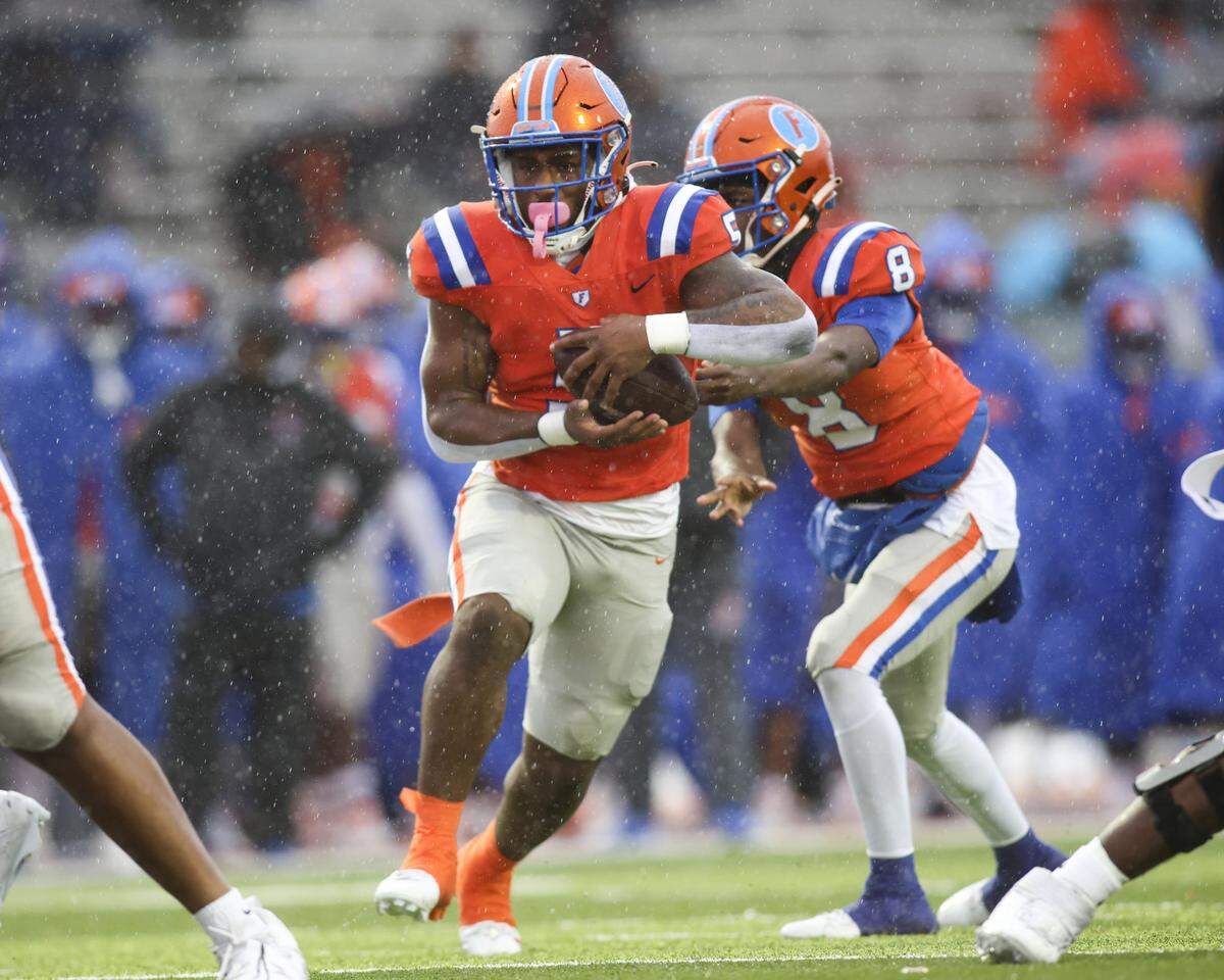 East St. Louis’ Larevious Woods (5) carries against Normal West in the second round of the IHSA Class 6A playoffs Saturday.