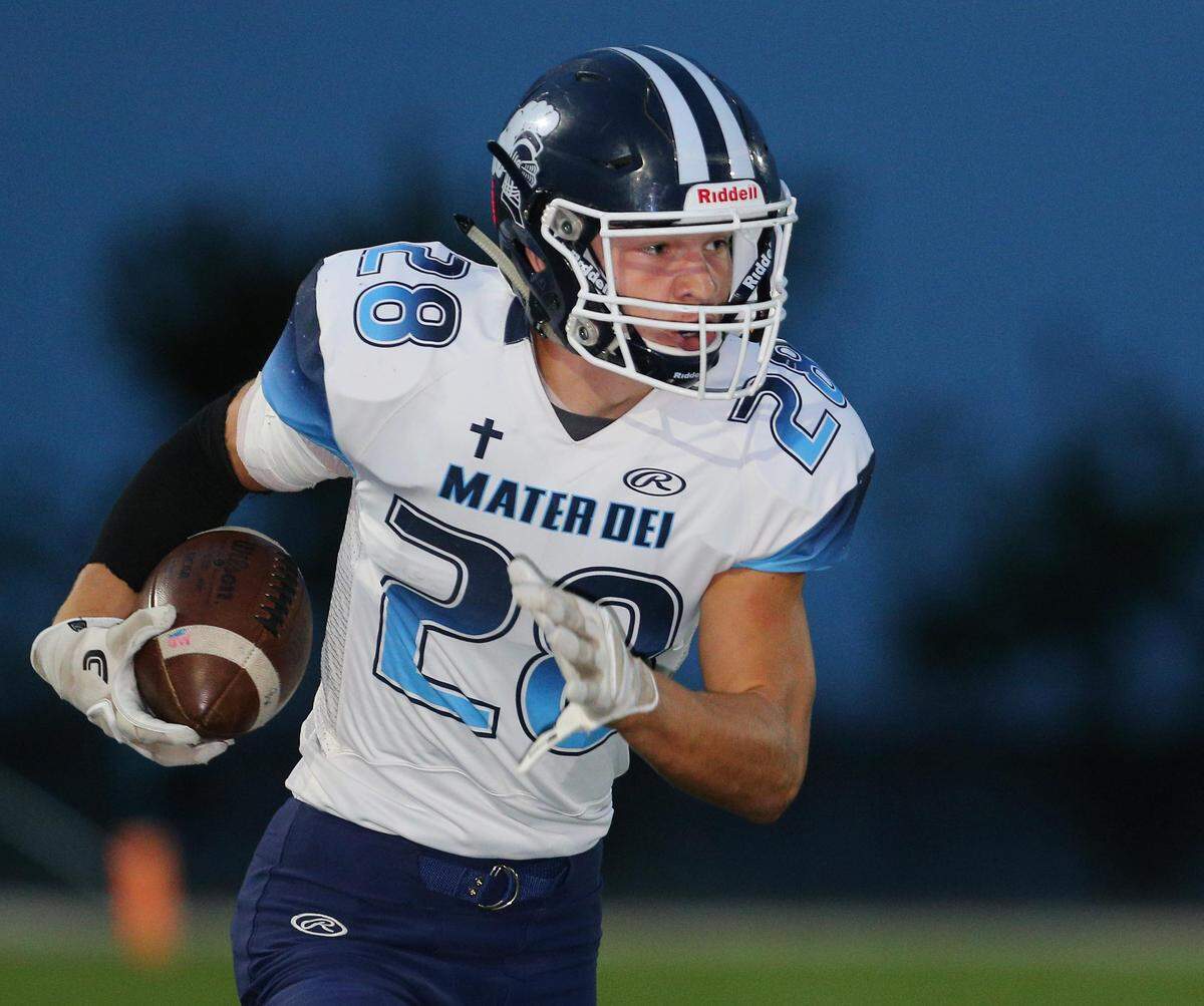 Mater Dei’s Logan Ratermann carries the ball against Central in the annual Milk Bowl game Friday night in Breese.