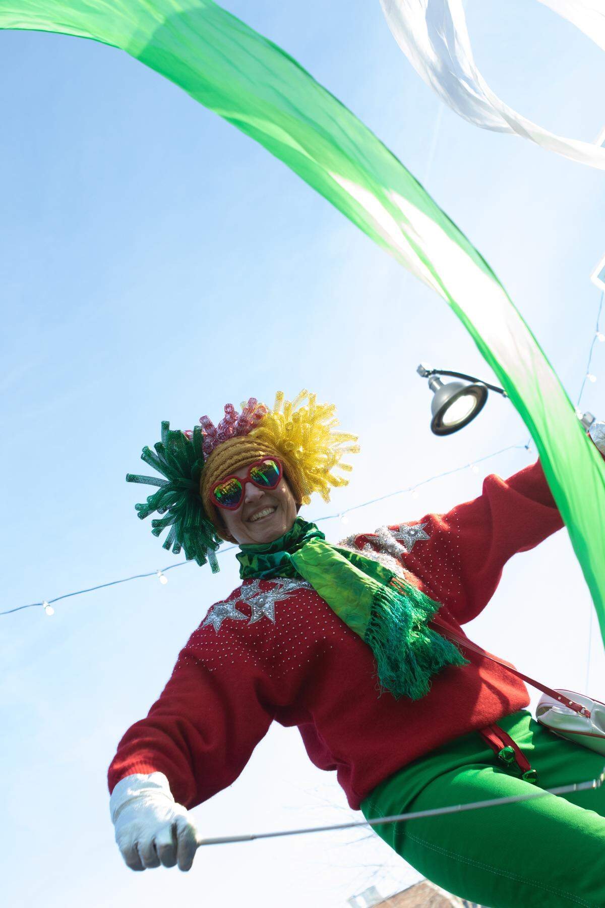 A flag-twirler on stilts makes her way down Main Street with surprising grace during the annual Santa parade.