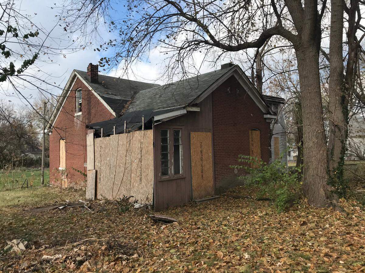 Someone has removed plywood over the kitchen window in back of a condemned German American folk house at 214 N. 11th St. in Belleville. The city is preparing to demolish it.