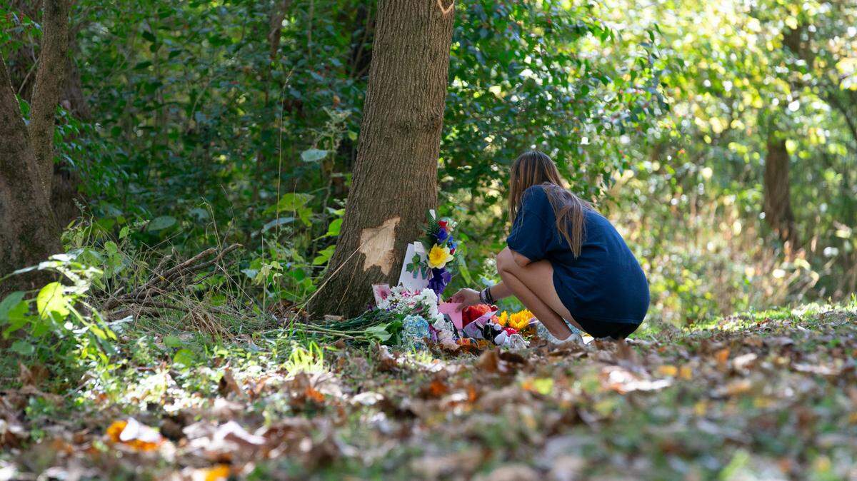 Shaylee Ficken places a card at a memorial for O’Fallon High School student Madeline Best Monday. Best died after a car crash on Bowler Road Friday.