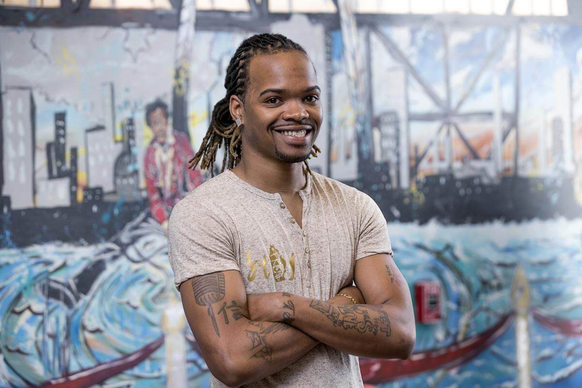 Fashion designer Jamel Stamps is wearing a shirt with his signature logo.