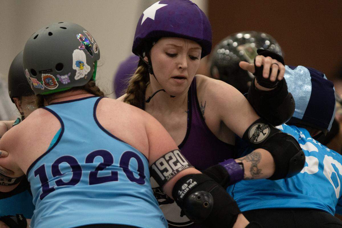 Abtitude, a member of Confluence Crush, tries to break through a group of defenders during a bout in Collinsville on May 31.