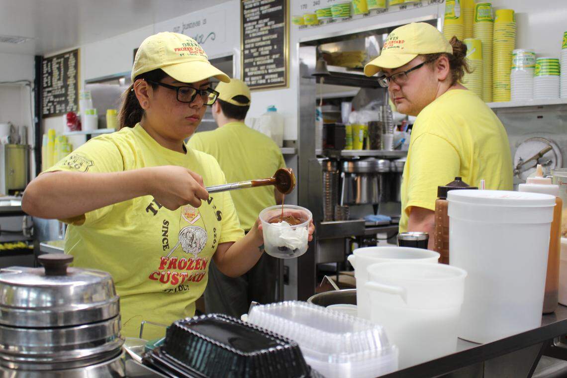 John Lindner watches as fellow employee Amanda Antonio puts toppings on sundaes at the Ted Drewes location on Chippewa in St. Louis.
