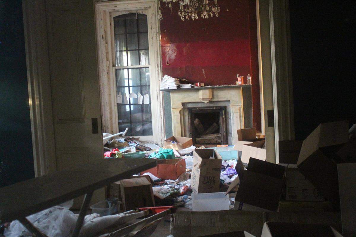 Rooms with massive pocket doors and a marble fireplace are filled with trash left by squatters in a historic home at 107 E. D St. in Belleville.