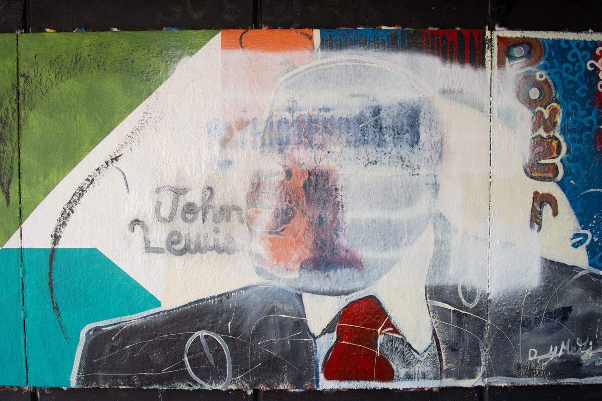 A white base coat remains, obscuring an image of the late U.S. Rep. John Lewis, after students tried to clean white nationalist graffiti off a mural of famous Black Americans at Washington University in St. Louis in December.