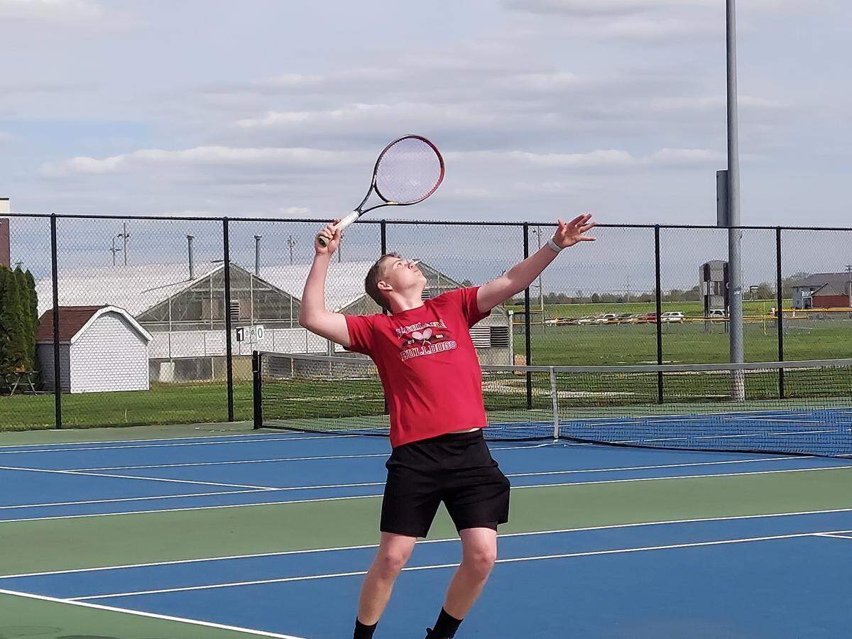 Highland’s Isaac Pasley sets to serve a shot during his No. 3 singles match against Granite City on Monday, April 25, at Highland High School. Pasley and the Bulldogs rolled to a 7-0 non-conference victory.