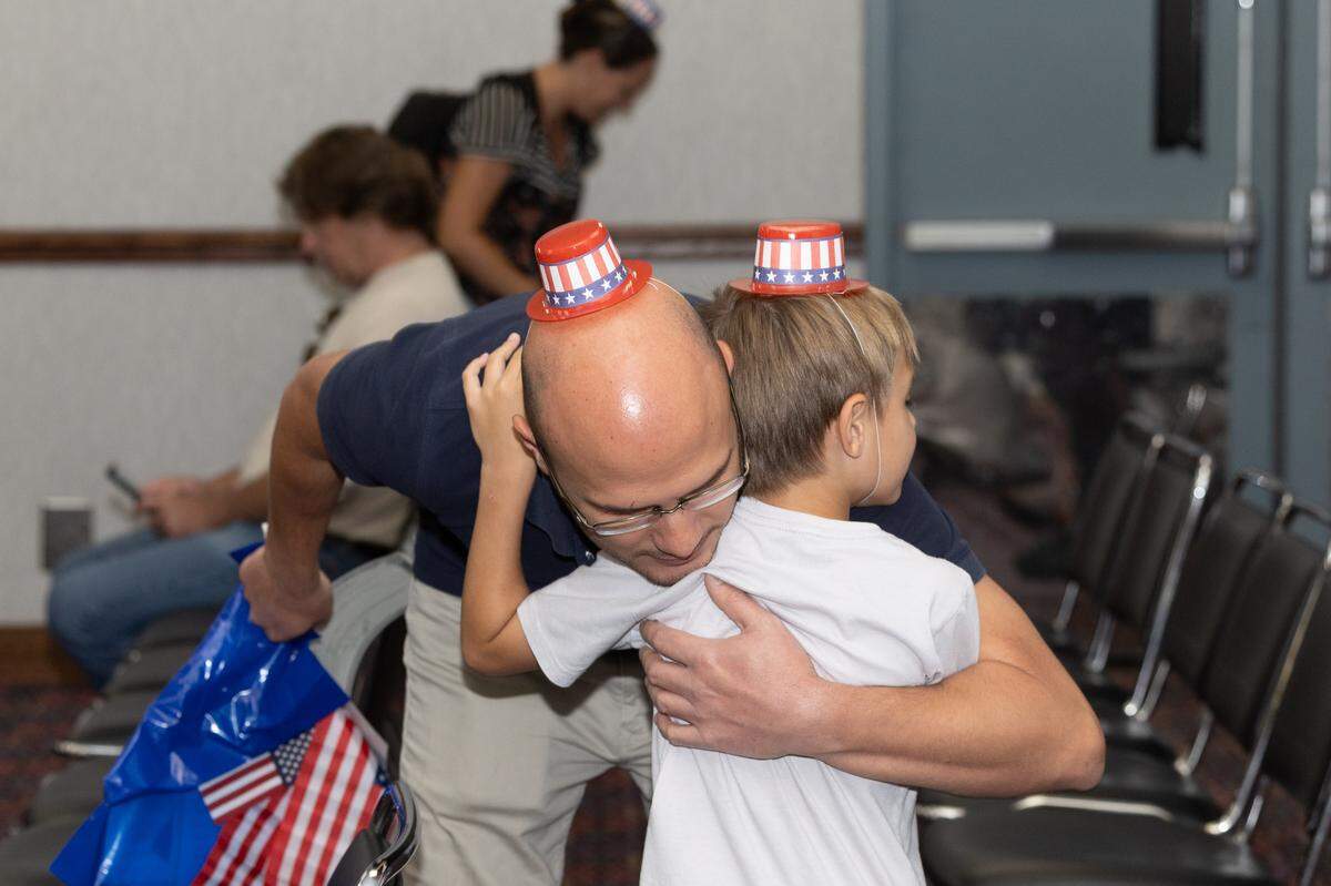 A father hugs his son after a naturalization ceremony in Collinsville.