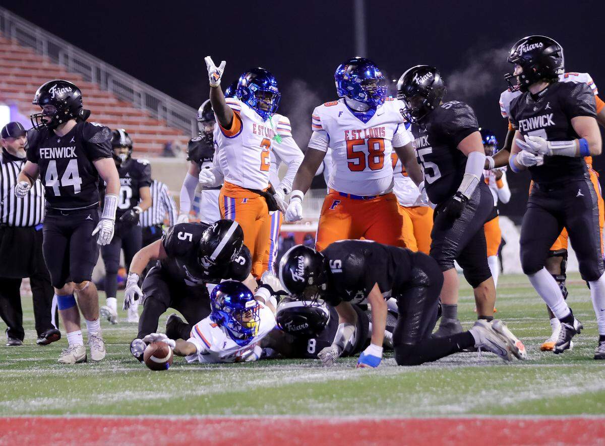 Laron Baker Jr reaches for a first down during the IHSA Class 6A championship game between East St. Louis and Fenwick.