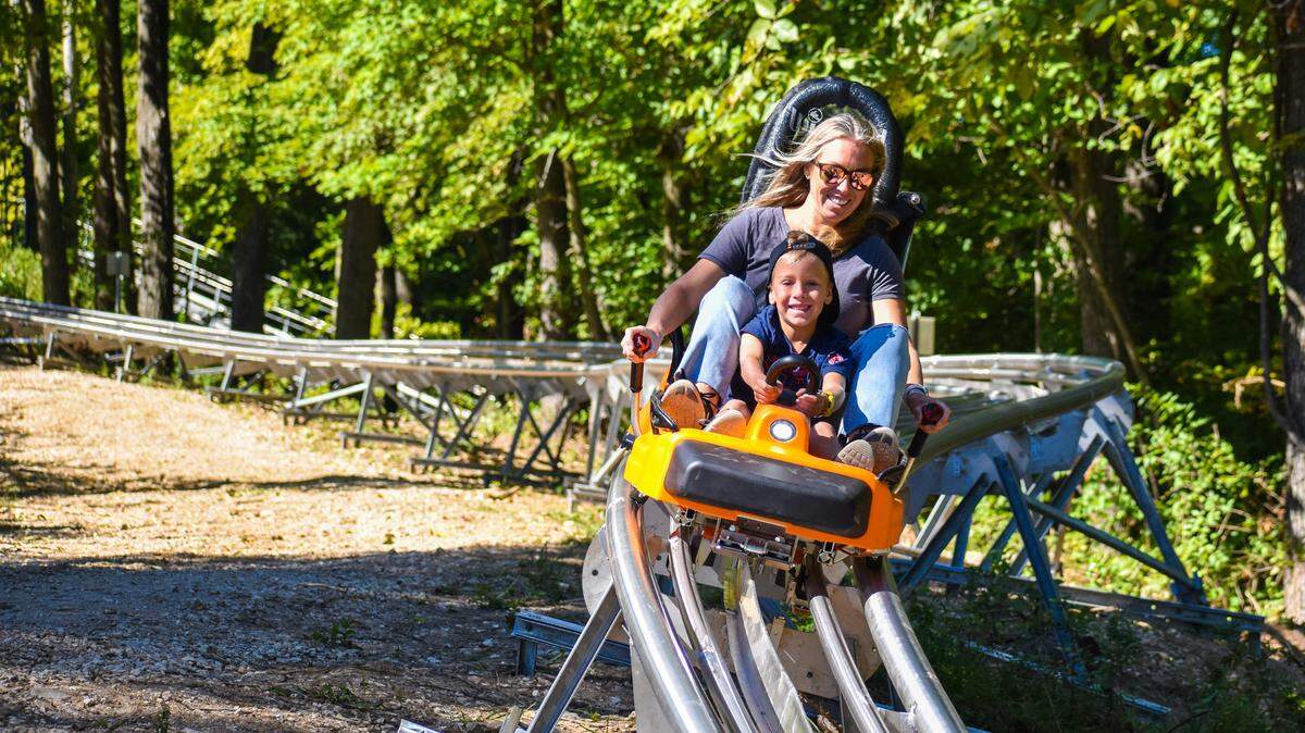 A mother and her child enjoy their first ride on the Aerie’s Alpine Coaster as they near the first curve of the track during the coaster’s official opening weekend.